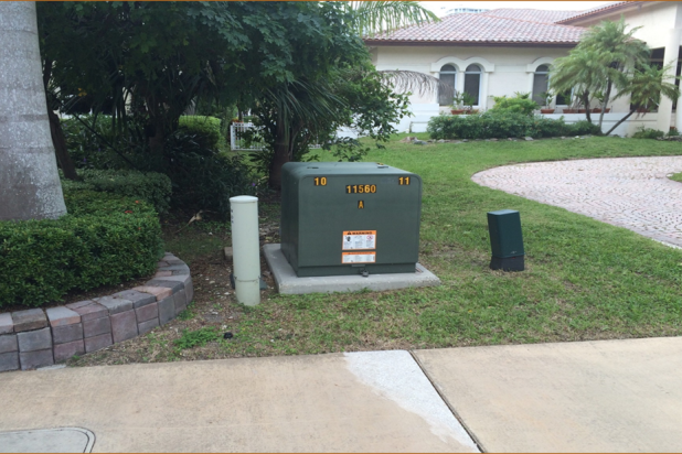 FPL pad-mounted transformer in front of a large house