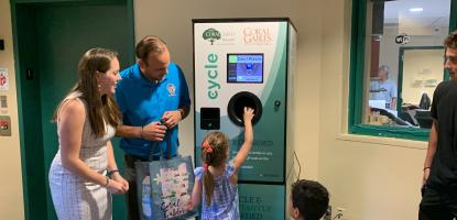 Children putting bottles in a "reverse vending machine"