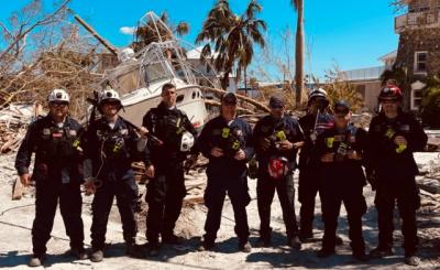 Coral Gables firefighters standing in front of debris after Hurricane Ian