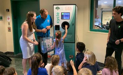 Children putting bottles in a "reverse vending machine"