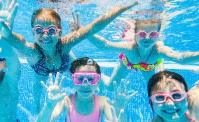 kids waving hello under the pool
